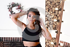 Pretty girl poses in studio with fireplace