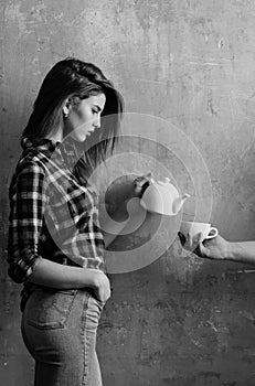 Pretty girl pouring tea to cup in male hand