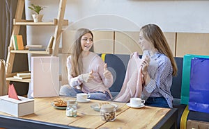 Pretty girl reacting with thumbs up to girlfriend new sweater