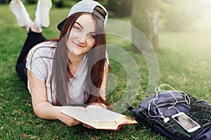 Pretty girl read book and listen music at park