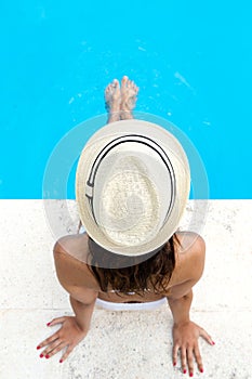 Pretty girl relaxing at the swimming pool in the summertime