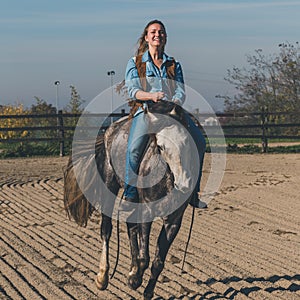 Pretty girl riding her grey horse