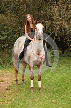 Pretty girl riding a horse without any equipment