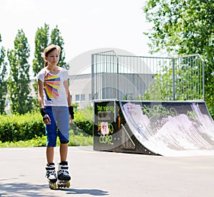 Pretty girl in rollerblades at the skate park