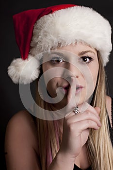 Pretty Girl with Santa Hat saying Shhhhh