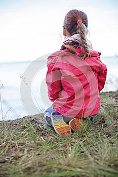 Pretty girl in shoes with rainbow color bottom sitting on the bank of sea, girls power and tolerance