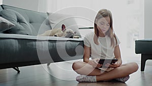 Pretty Girl Sits on the Floor Near Sleepy Pet.