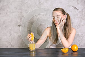 Pretty girl squeezing orange