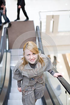 Pretty girl standing on escalator