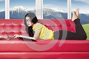 Pretty girl studying on sofa