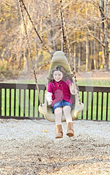 Pretty girl swinging in the park