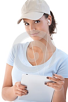 Pretty girl with tablet and earbuds smiling