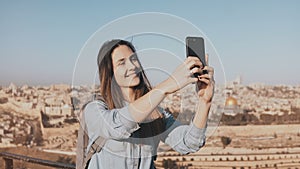 Pretty girl takes selfie in Jerusalem old town. Cute local girl smiles happy, taking photos. Ancient Israel panorama 4K.