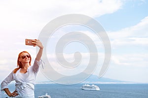 Pretty girl Takes a selfie photo. Sea and horizon in the background. Vacation and travel concept. Communication on a mobile