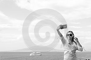 Pretty girl Takes a selfie photo. Sea and horizon in the background. Vacation and travel concept. Communication on a mobile