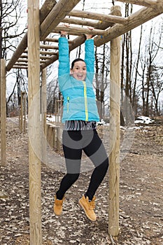 Pretty girl training on monkey bars obstacle