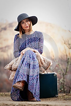 Pretty girl with vintage case on a dirtroad