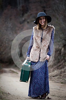 Pretty girl with vintage case on a dirtroad