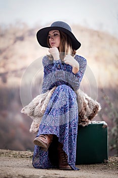 Pretty girl with vintage case on a dirtroad