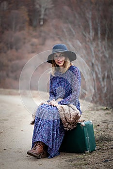 Pretty girl with vintage case on a dirtroad