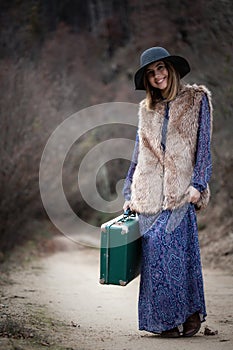 Pretty girl with vintage case on a dirtroad