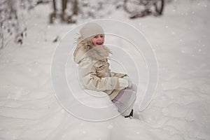 Pretty girl in warm wool clothes, with cold winter iced background with expressive emotions on her beautiful face, winter portrait