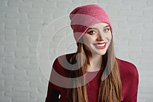 Pretty girl wearing pink cap on the grey background. photo