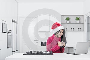 Pretty girl with laptop and Santa hat