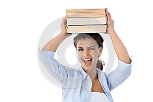 Pretty girl winking with books on her head