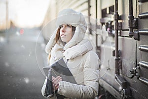 Pretty girl in winter blizzard on railroad station