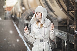 Pretty girl in winter blizzard on railroad station