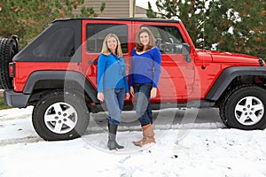 Pretty girls having fun by a Jeep