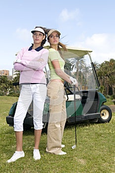 Pretty golf players with their golf cars