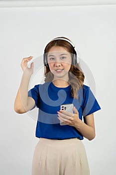Pretty happy asian teenage girl using mobile phone playing music from smartphone application, happy smiling