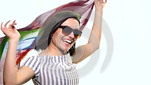 Pretty happy smiling woman with her hands up in the air playing with beautiful silk scarf against on a white background