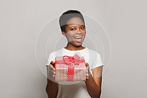 Pretty healthy woman giving colorful gift present box on white background. Celebration and holiday concept