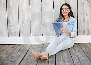 Pretty hipster sitting on ground with tablet