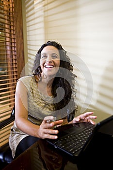 Pretty Hispanic woman using laptop computer