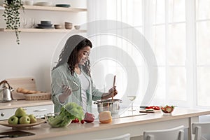 Pretty housewife tasting fresh meal at home. Chef taste food, cook, covid-19
