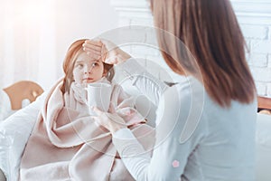 Pretty ill girl looking at her mother