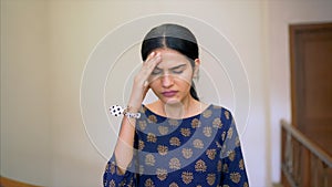 Pretty Indian girl suffering from a severe headache - health and medical concept