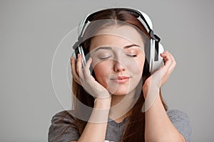 Pretty inspired young woman listening to music with eyes closed