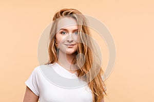 Pretty jovial smiling girl with redhair.Isolate on pale yellow background.