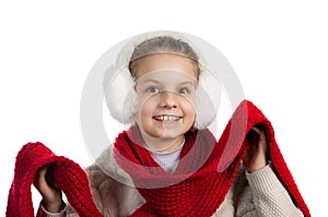 Pretty joyful little girl in warm winter things with knitted scarf