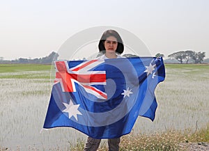 pretty lady is holding Australia fabric flag in her hands nature view background