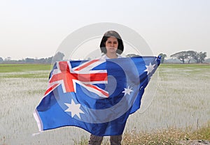 Pretty lady is holding Australia fabric flag in her hands nature view background