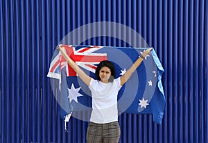 pretty lady is holding Australia flag in her hands and raising to the end of the arm