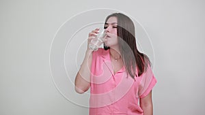 Pretty lady keeping glass of water, drink water doing winner gesture with fist