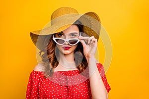 Pretty lady look window dislike rainy weather wear red dress sun specs and hat isolated yellow background