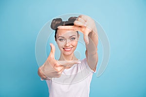 Pretty lady making imaginary photo focus with hands wear white casual t-shirt  blue bright background